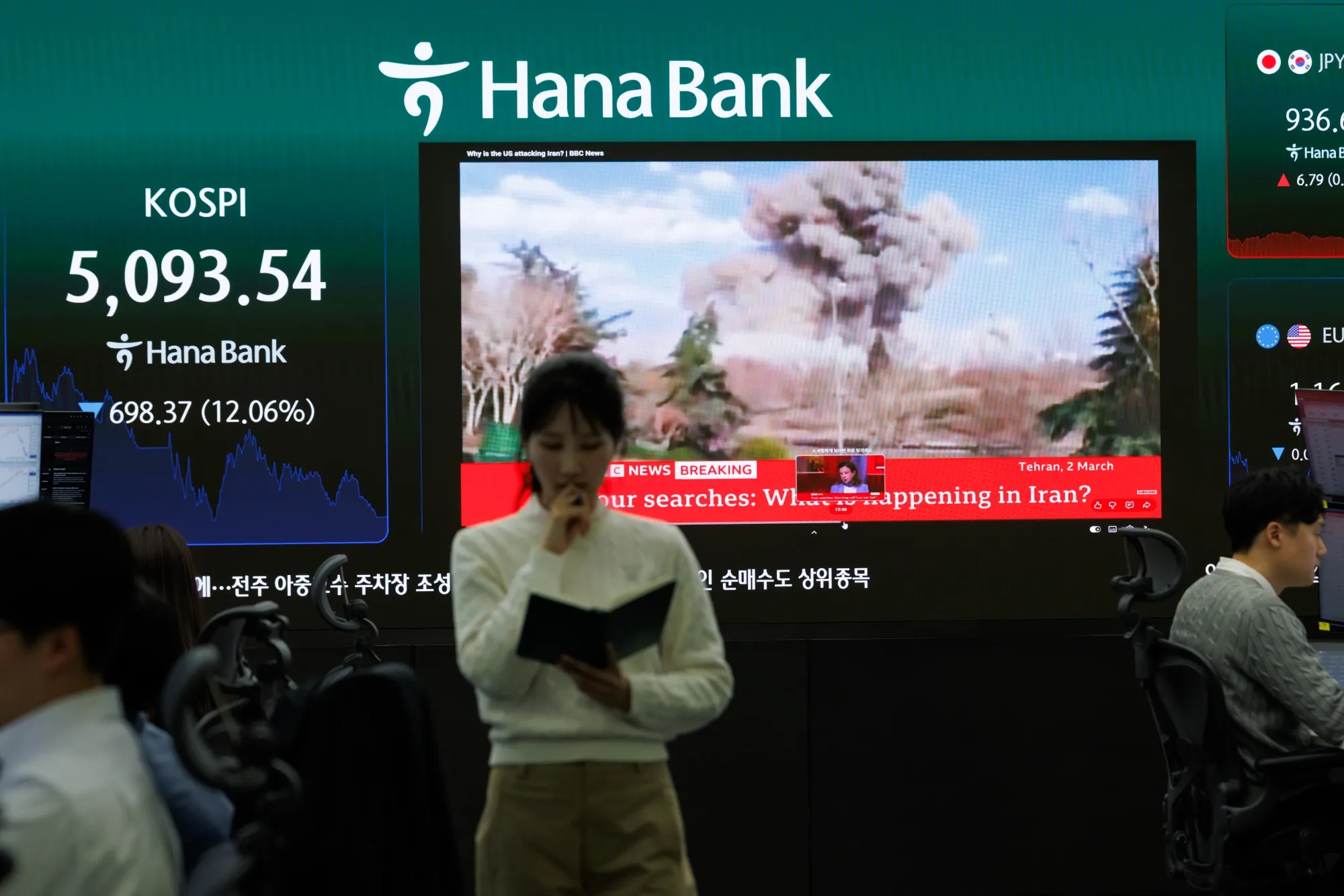 A news report on the Iran conflict displayed inside a trading room at Hana Bank in Seoul.