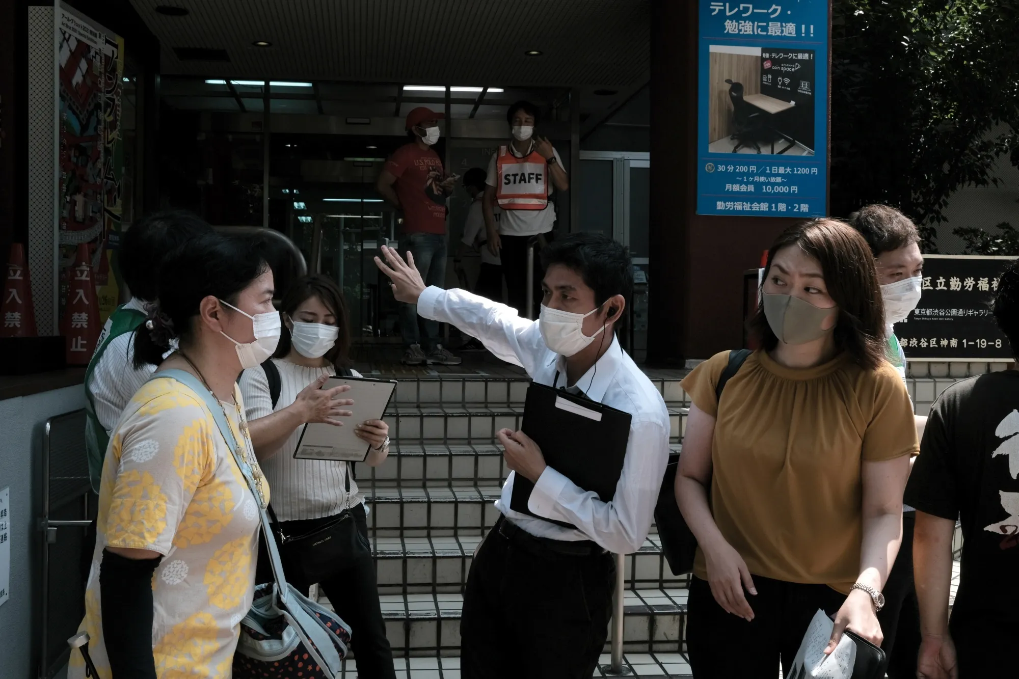 A staff member assists residents at a walk-in Covid-19 vaccination site in Tokyo, on Aug. 27.