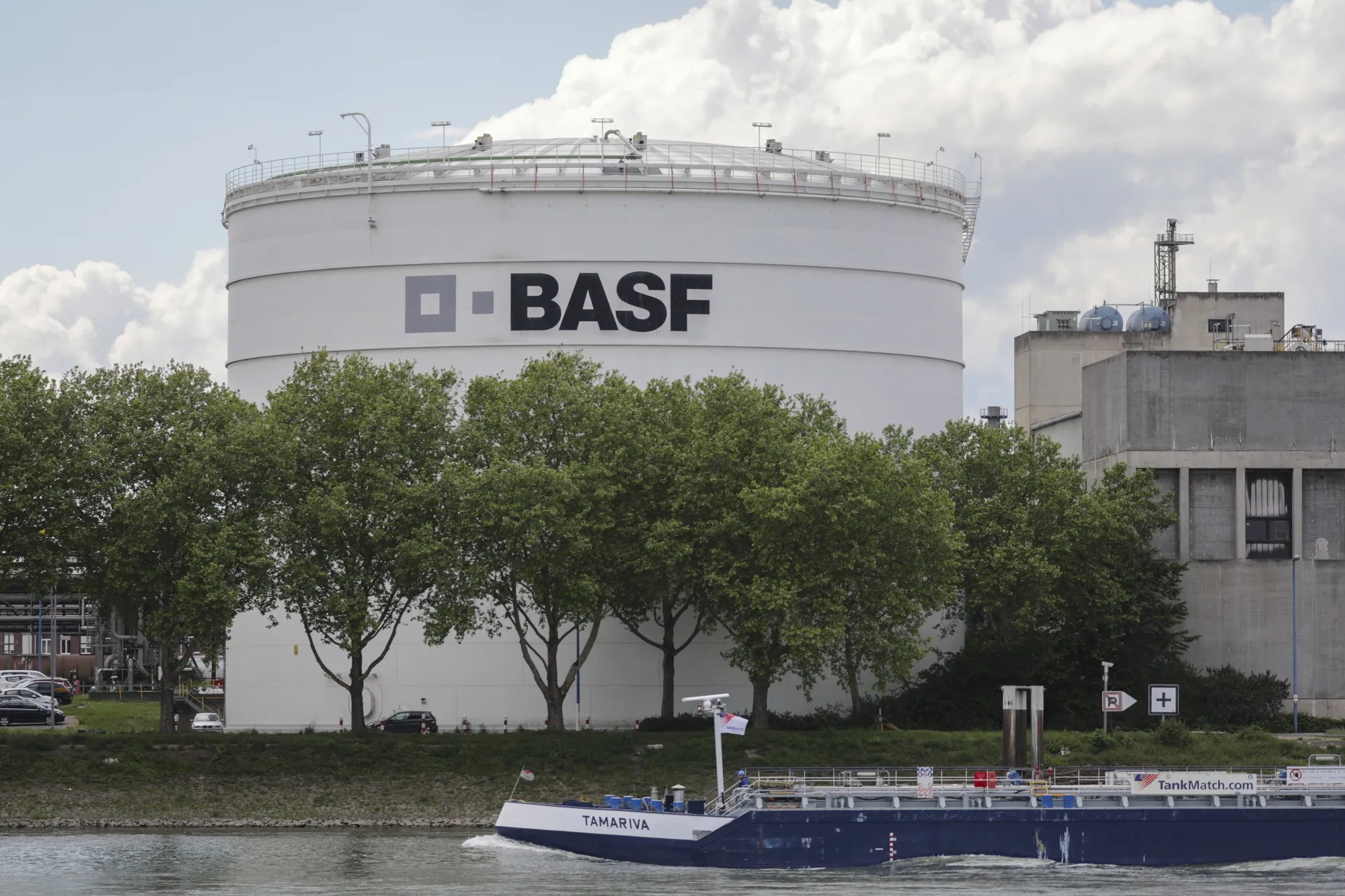 A chemical tanker barge sails past a silo at the BASF SE headquarters chemical plant on River Rhine in Ludwigshafen, Germany.