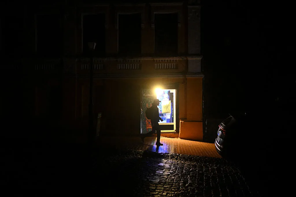 A man walks past a shop supplied with electricity from a power generator during blackout hours in Kyiv, Nov. 21.