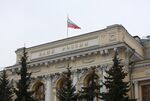 A Russian national flag flies above the headquarters of Bank Rossii, Russia's central bank.