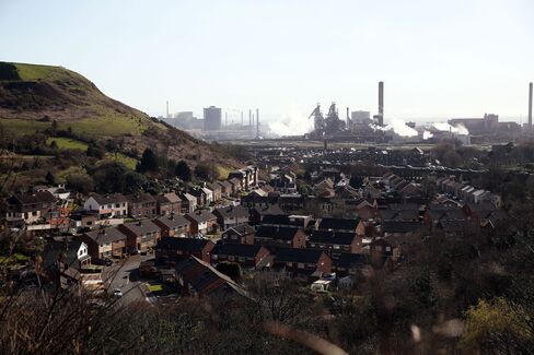 Residential houses stand against a backdrop of the steel works in Port Talbot.