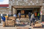 Residents move bricks during a cleanup operation following rioting in the Soweto district of Johannesburg on July 15.