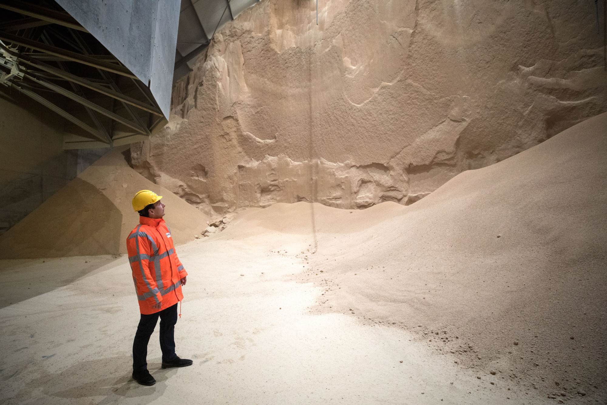 An employee looks at soybean meal produced by Glencore Plc as it is stored before transportation in a grain flat storage at the European Bulk Services (E.B.S.) terminal at the Port of Rotterdam in Rotterdam, Netherlands, on Tuesday, April 25, 2017.&nbsp;