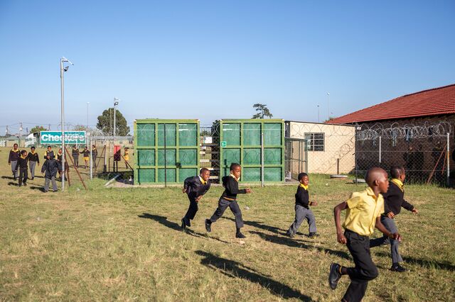 Children at the Tsholetsega Public School in Johannesburg, South Africa, run past the Clear Enviro Loo Recirculation Water Treatment Plant, that has been installed in the school.