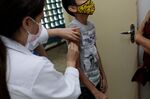 A healthcare worker administers a dose of the Sinovac Covid-19 vaccine to a child in Sao Paulo, Brazil.