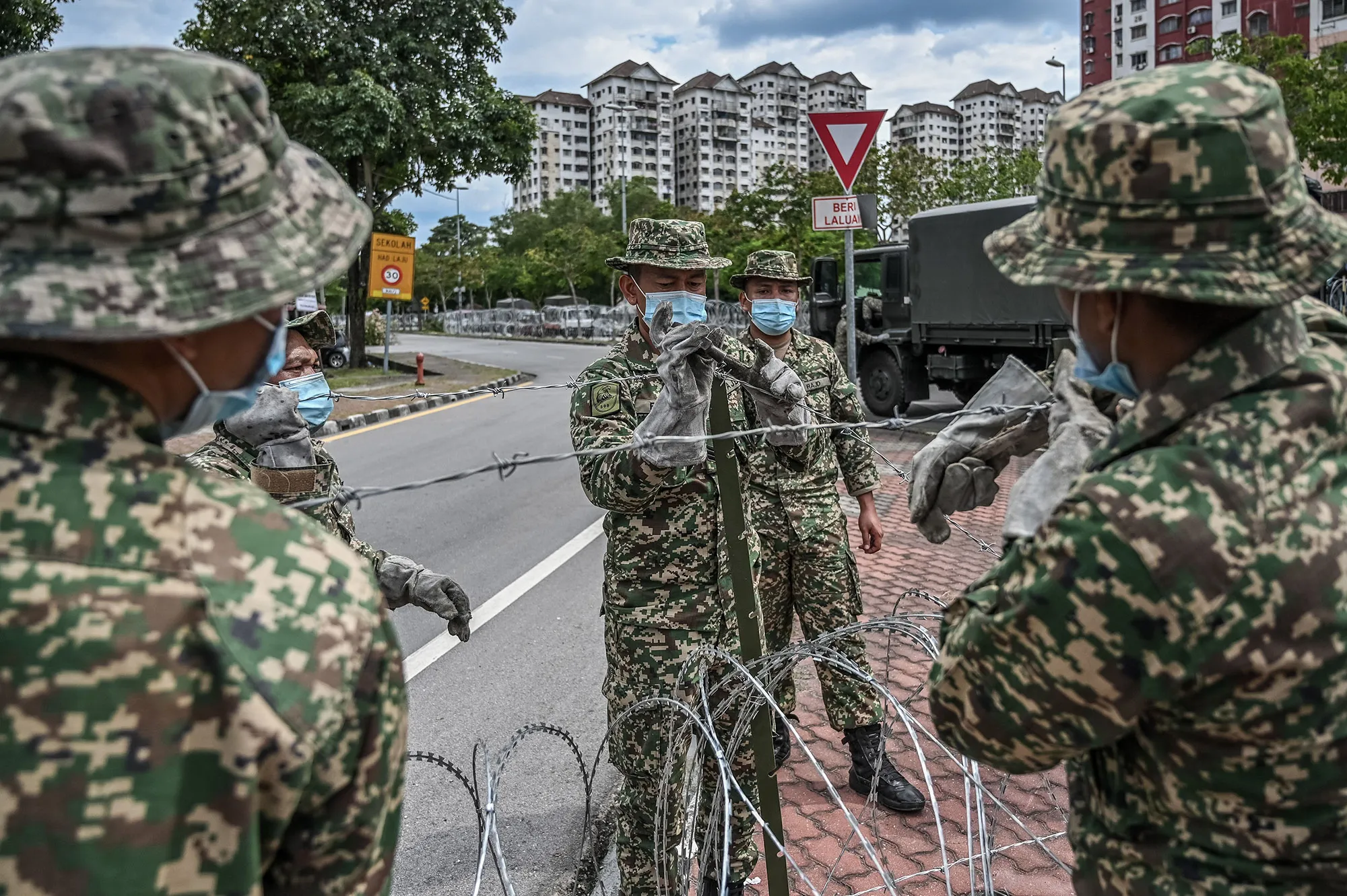 Malaysian soldiers install barbed wire near apartment buildings after authorities locked down the area to stop the spread of the coronavirus.