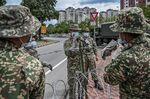 Malaysian soldiers install barbed wire near apartment buildings after authorities locked down the area to stop the spread of the coronavirus.