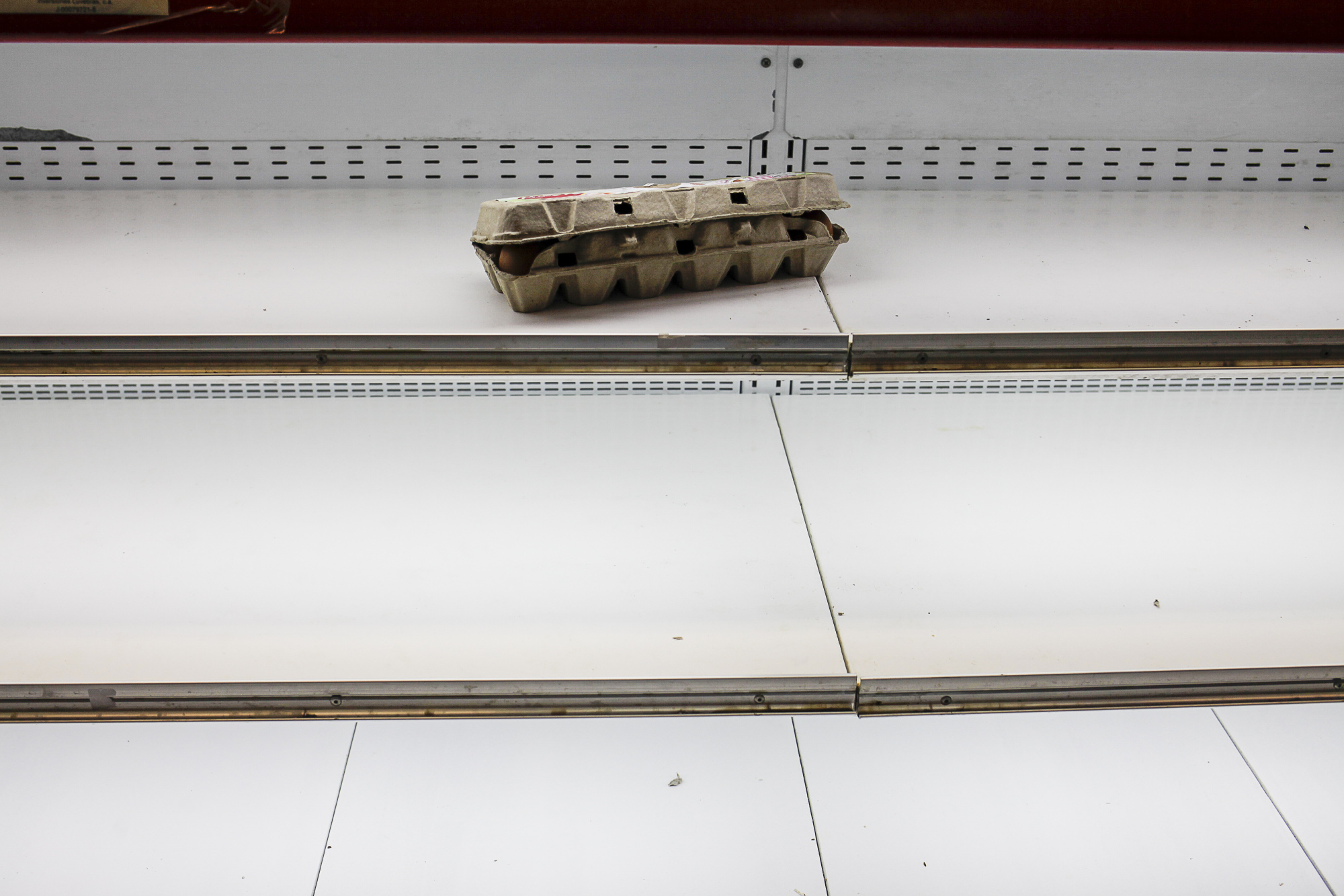 A carton of eggs sits on an empty shelf at a supermarket in the Chacao district of Caracas, Venezuela, on Aug. 24, 2017.
