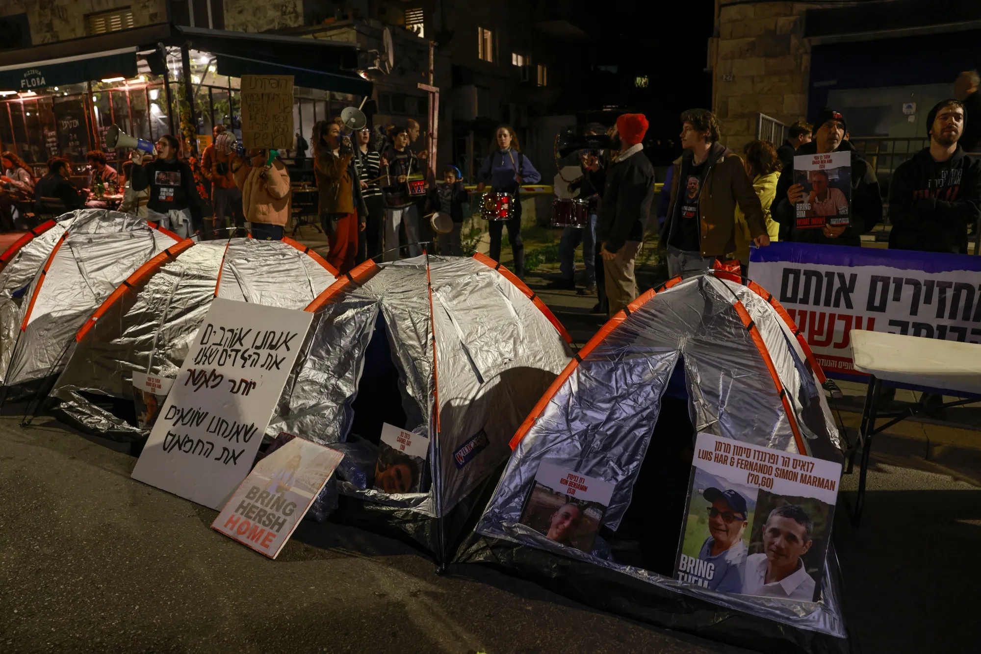 Protestors stand behind tents near the residence of the Israeli prime minister in Jerusalem during a rally organized by family and supporters of Israeli hostages held in Gaza.