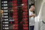 International currency exchange rates stand on display in the widow of a bureau as a worker handles Euro currency notes, in the Grand Bazaar in Istanbul, Turkey, on Friday, Aug. 10, 2018. A plunge in the lira sent tremors through global markets on Friday as tensions flared between the U.S. and Turkey, a pair of NATO allies.