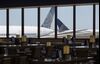 United Airlines Holdings airplanes stand past an empty waiting area for travelers at Newark International Airport on June 9.