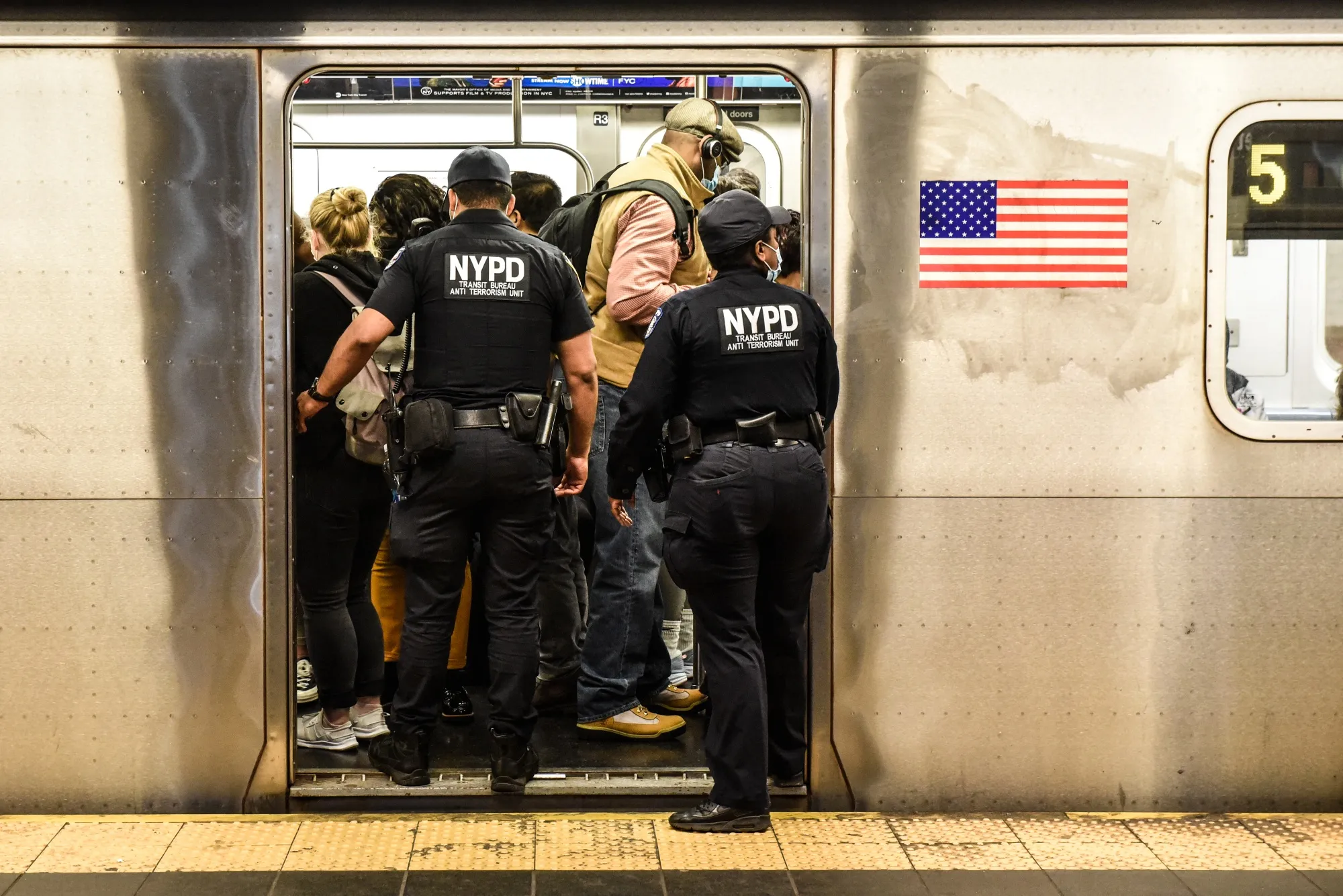 New York Police Department officers enter a subway at a station in New York.