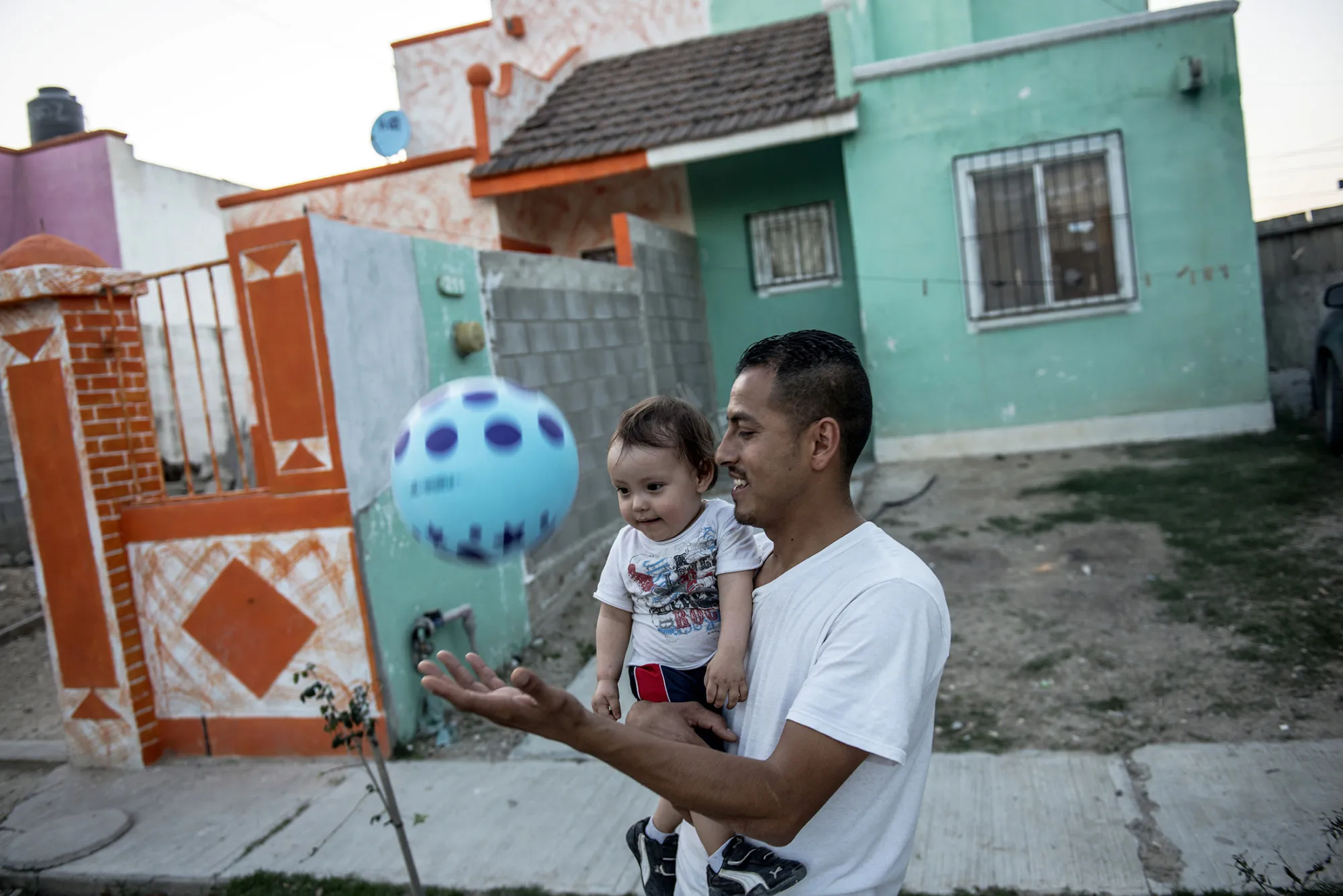 Manuel Aragon plays with his one-year-old son in Acuna, Mexico.
