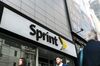 Pedestrians pass in front of a Sprint Corp. store in New York, U.S.