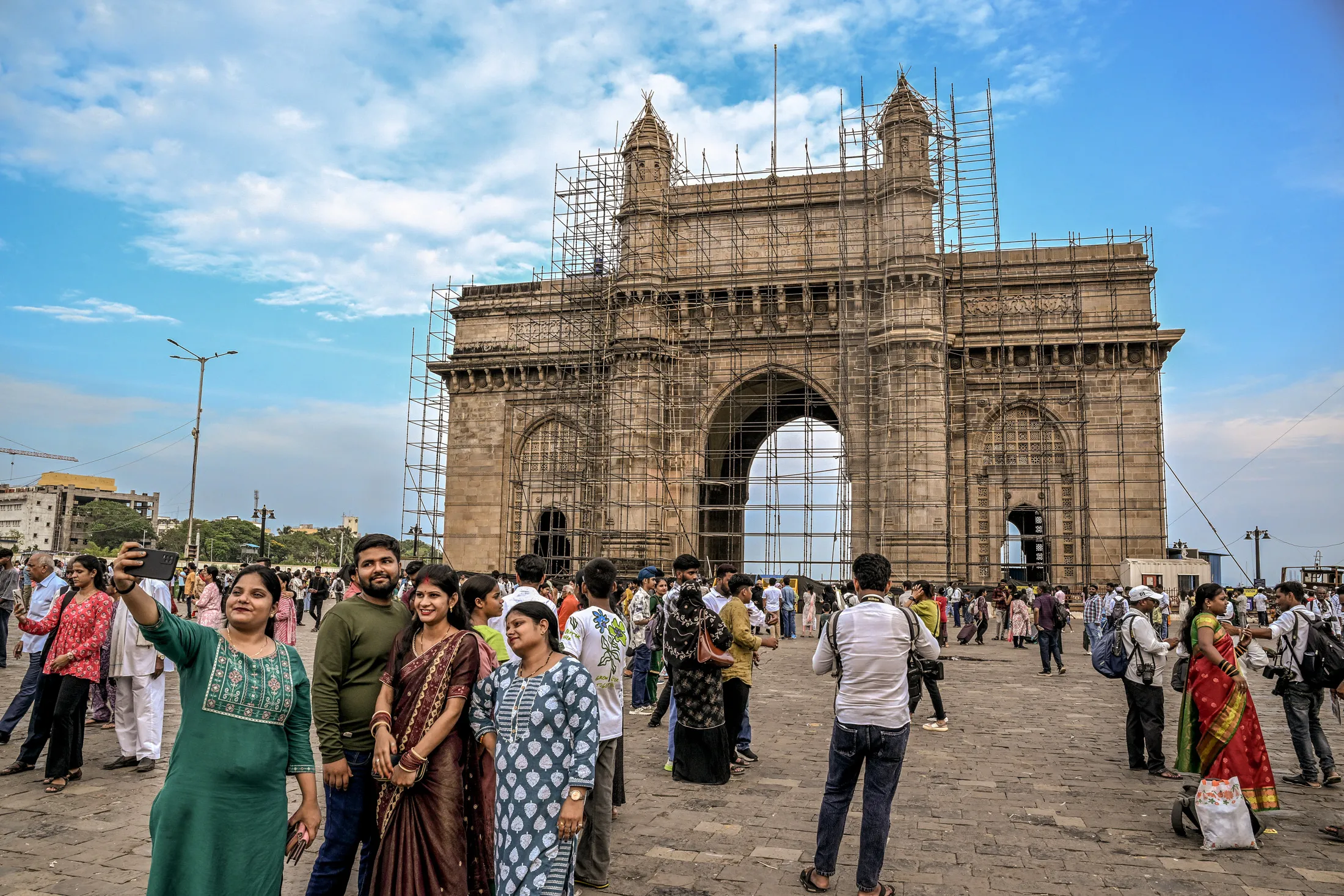 
Tourists in front of the Gateway of India on May 21, 2025. The monument is under extensive restoration after years of sea-worn decay and damage.
