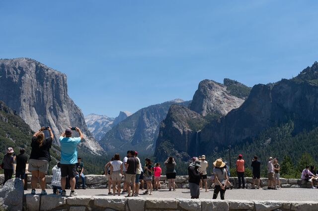 Visitors taking photos of Yosemite Valley and the park’s most famous peaks at Tunnel View.