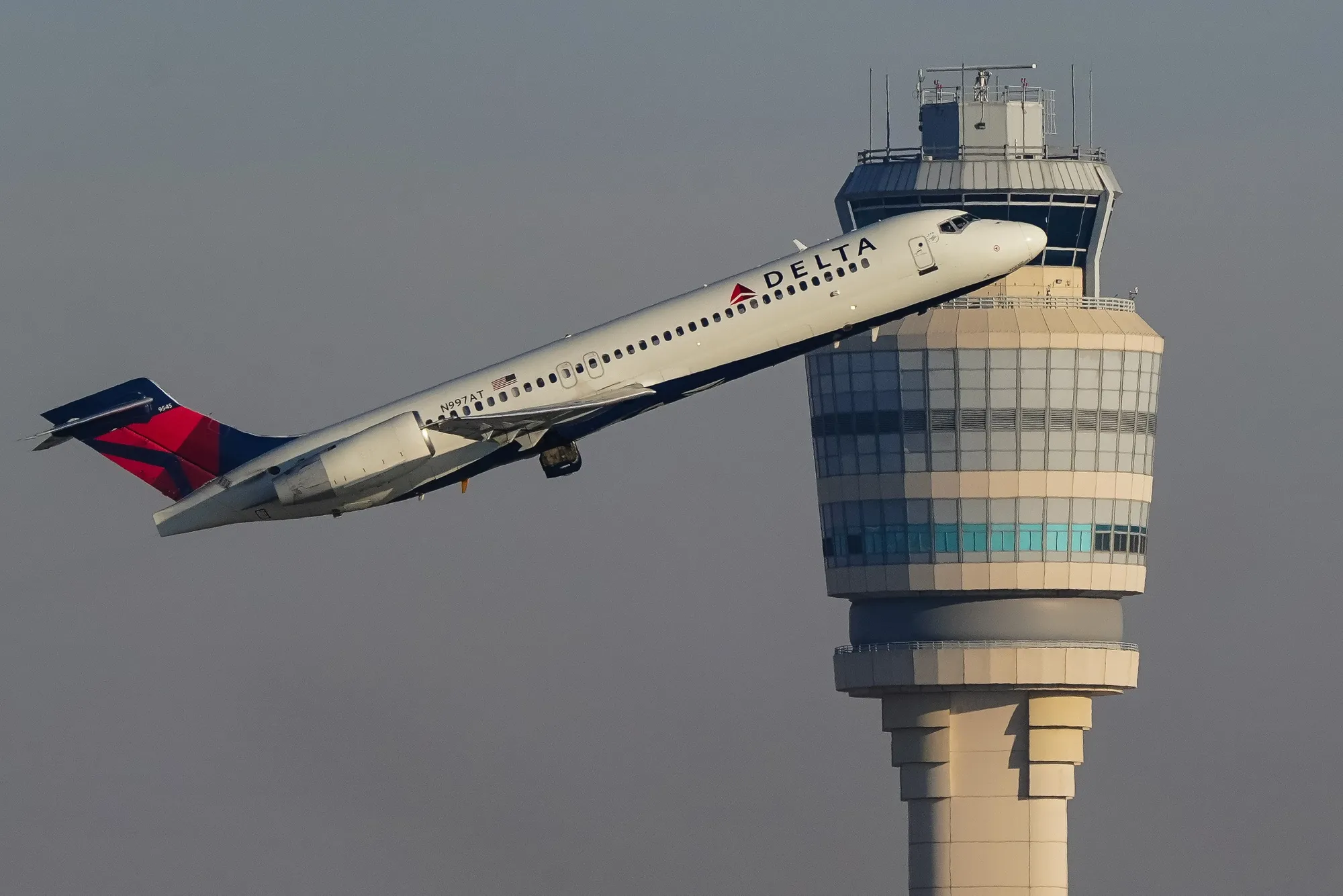 A Delta plane takes off near an air traffic control tower at Hartsfield-Jackson Atlanta International Airport