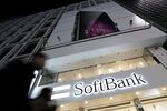 Pedestrians walk past a SoftBank Corp. store at night in Tokyo, Japan.