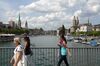Pedestrians walk over the Quaibruecke, in front of the Grossmuenster church, background right, in Zurich, Switzerland.