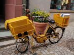 An electric cargo bike can carry heavier loads easily, such as this one being used by the German postal service.