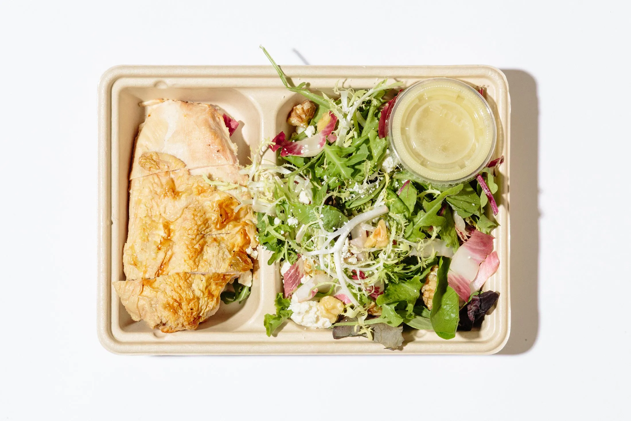 Munchery’s roasted chicken with frisée, walnut, and blue cheese salad.
