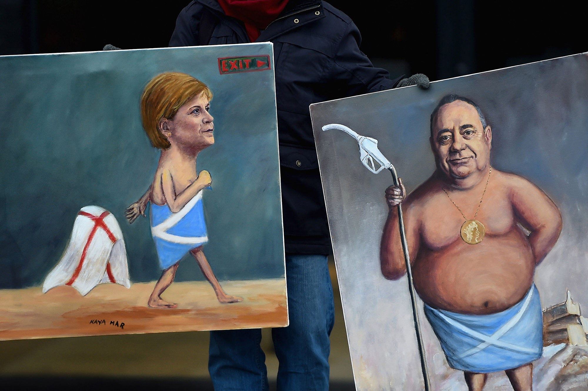 Artist Kaya Mar holds his paintings of Nicola Sturgeon and Alex Salmond outside the 81st SNP conference in&nbsp;Aberdeen.
