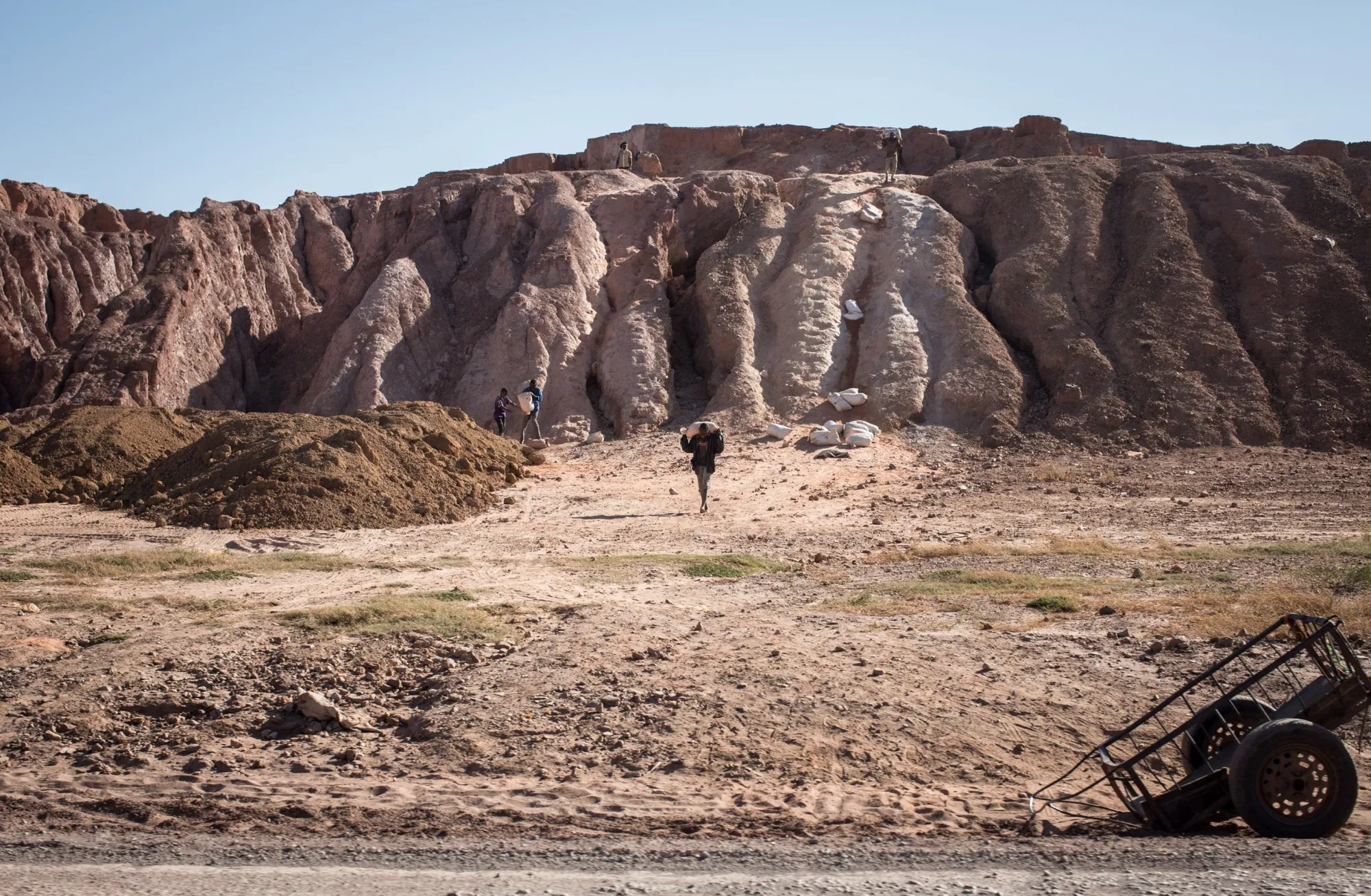 Young men carry minerals near the Gecamines factory in Kolwezi, Democratic Republic of Congo.