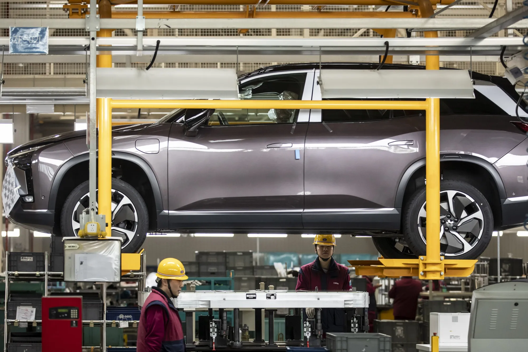 Workers install batteries onto an electric SUV at a Nio production facility in&nbsp;China, on Dec. 4.
