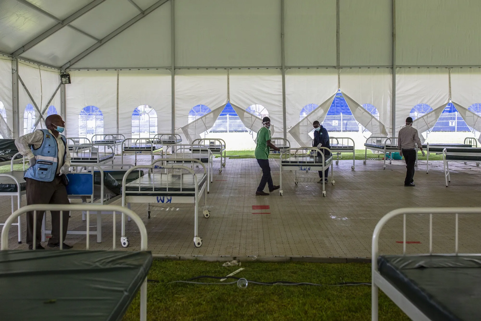 Workers push trolley beds into position at a field hospital near Nairobi.