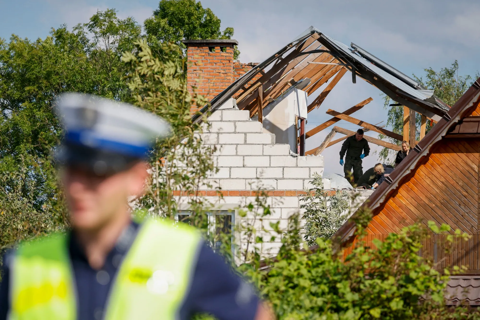 Officials inspect damage to a property after it was struck by drone debris, in Wyryki-Wola, Poland, on Sept. 10.