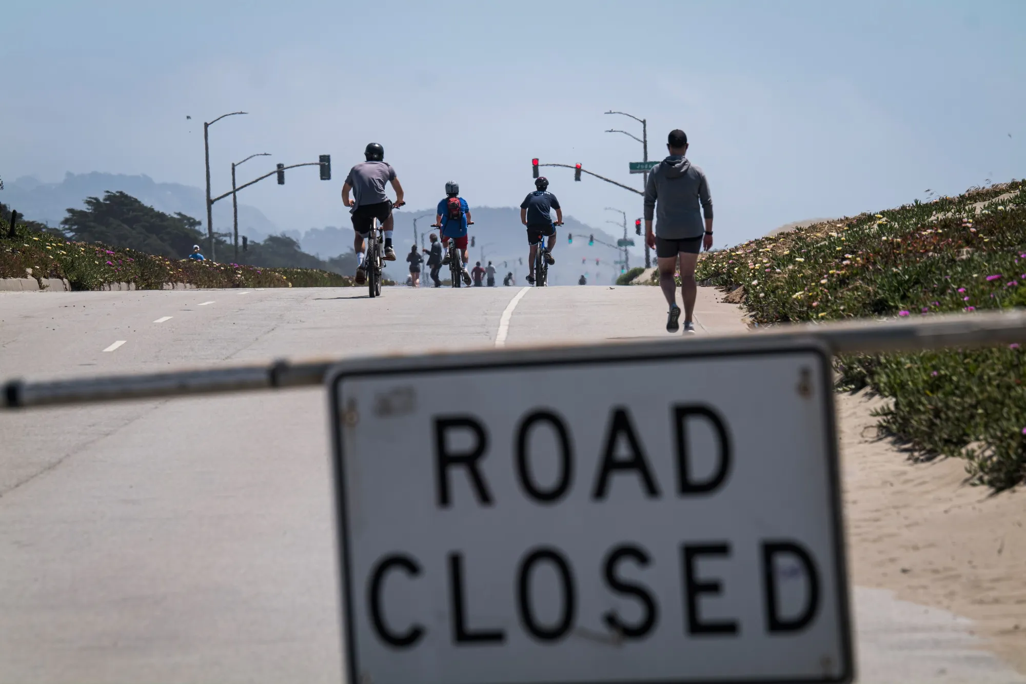 People cycle and walk on a closed Great Highway at Ocean Beach in San Francisco on April 30, 2020.