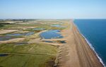Aerial view looking west across Salthouse and Cley Marshes, village of Cley on left, towards Blakeney Harbor and Point North Norfolk