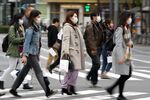 Pedestrians wearing protective masks cross an road in the Ginza area in Tokyo, Japan.