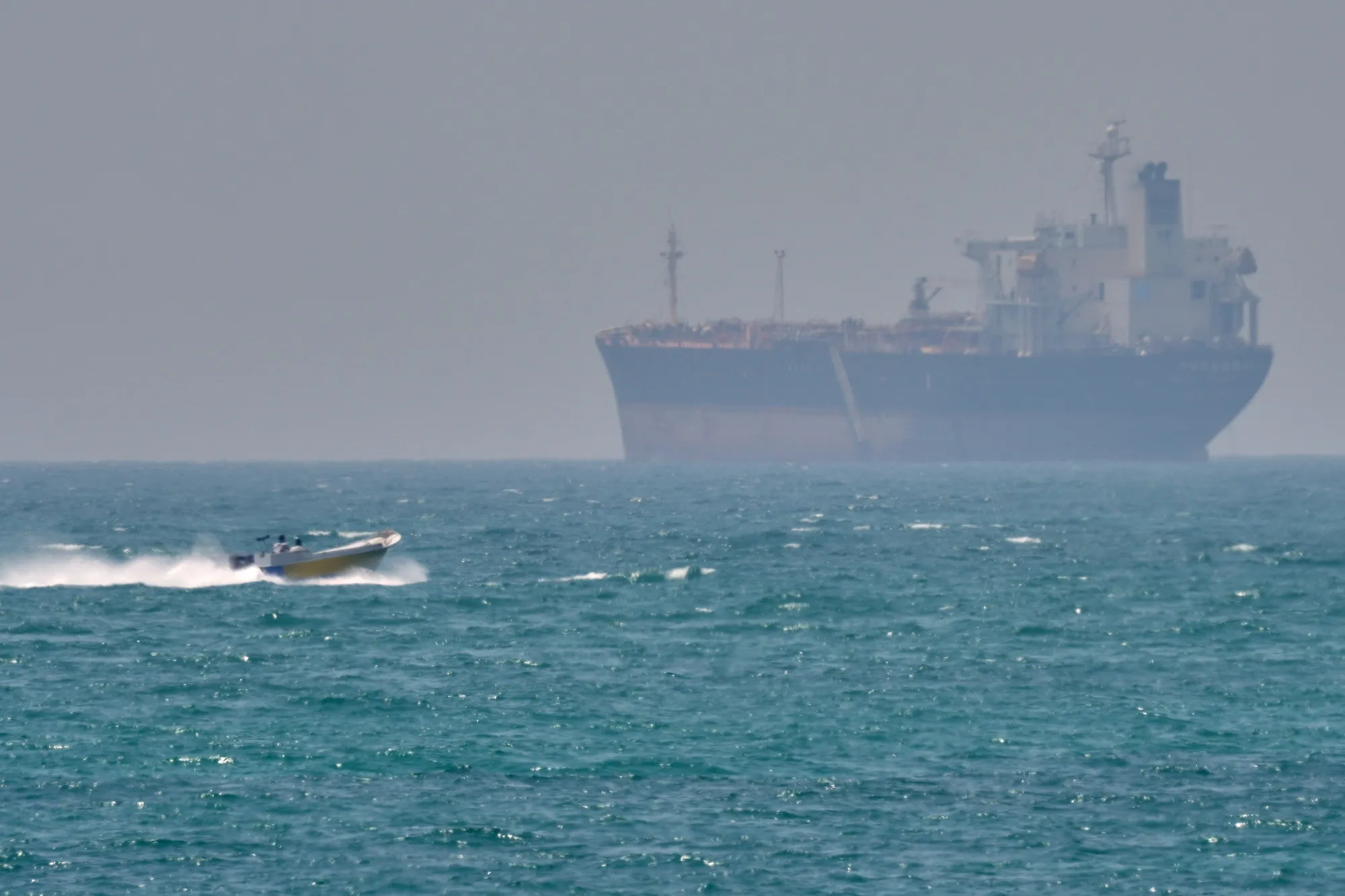 A boat sails past a tanker anchored on the Strait of Hormuz off the coast Qeshm island, Iran, on April 18.