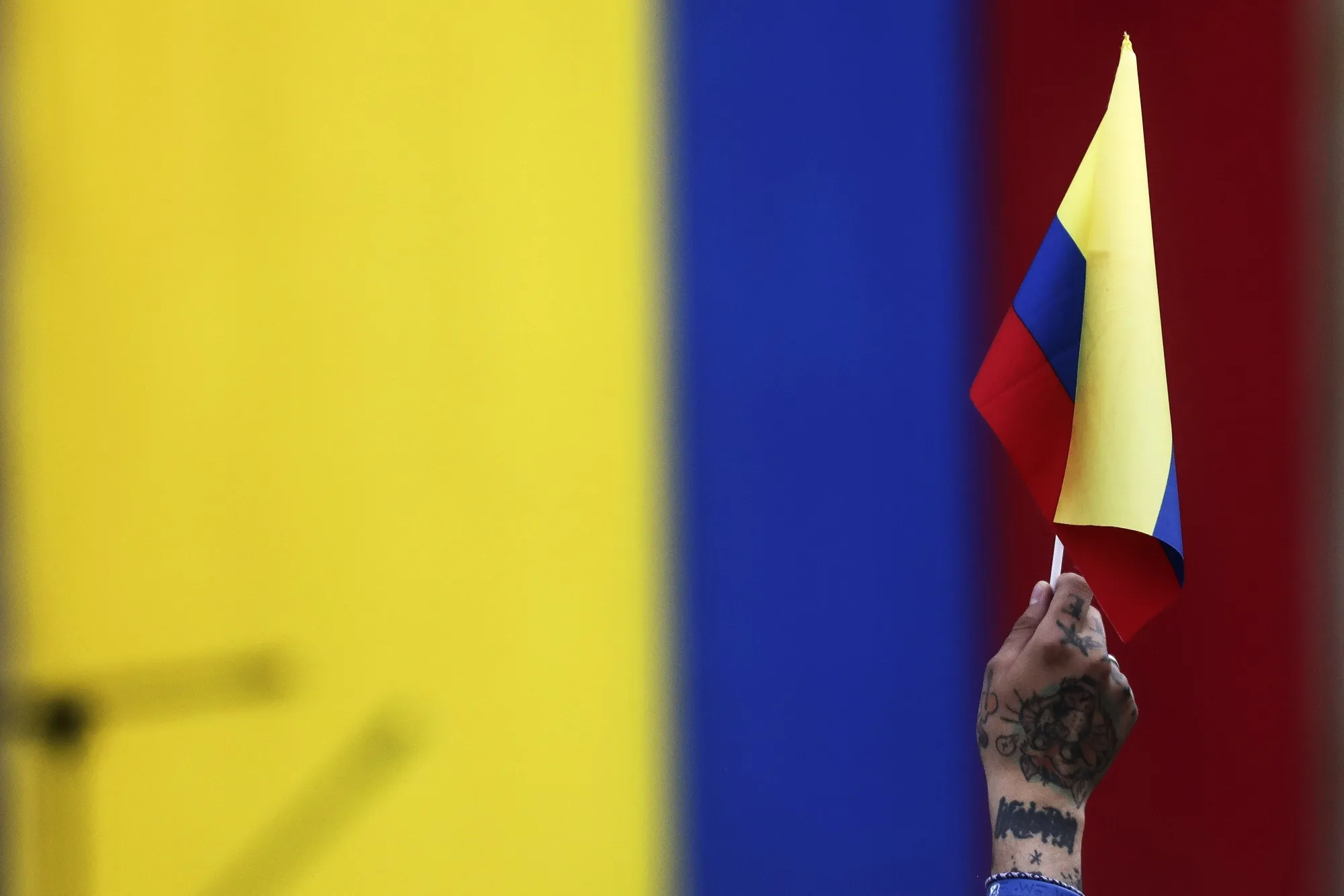 A demonstrator holds a Colombia flag during a pro-government march to Bolivar Square in Bogota, Colombia, on Tuesday, Feb. 14, 2023. President Gustavo Petro’s plans to overhaul the Colombian welfare state are facing their first big test as his supporters take to the streets to pressure lawmakers debating his controversial health care bill.