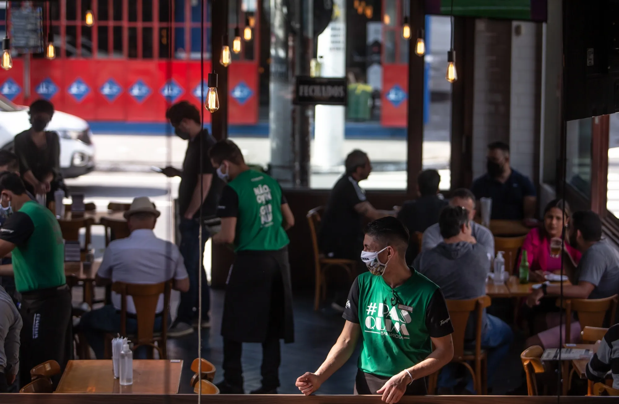 Servers wearing protective masks work at restaurant in the Vila Madalena neighborhood of Sao Paulo on July 6.