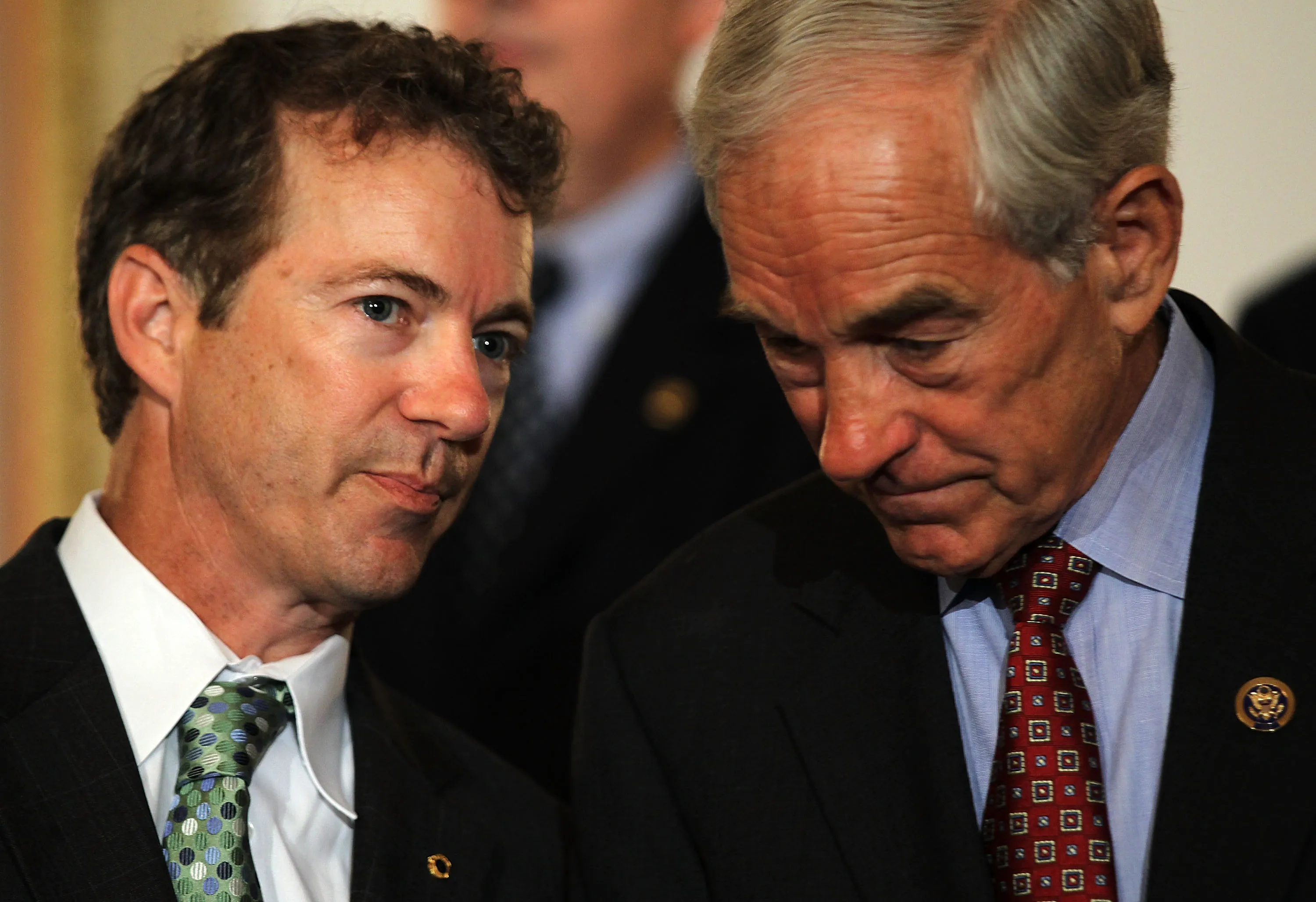 U.S. Sen. Rand Paul talks to his father, then Rep. Ron Paul, during a news conference June 22, 2011 on Capitol Hill in Washington, DC.

