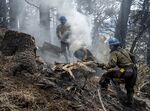 Wildland firefighters cut up a hollow tree that was burning at&nbsp;the Calf Canyon/Hermits Peak Fire in the Carson National Forest west of Chacon, New Mexico, on May 23.