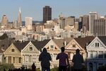 The silhouettes of pedestrians stand in front of Victorian homes and the downtown skyline in San Francisco, California, U.S., on Tuesday, Dec. 29, 2015. Home values in 20 U.S. cities rose at a faster pace in the year ended October as lean inventories of available properties combined with steadily improving demand.
