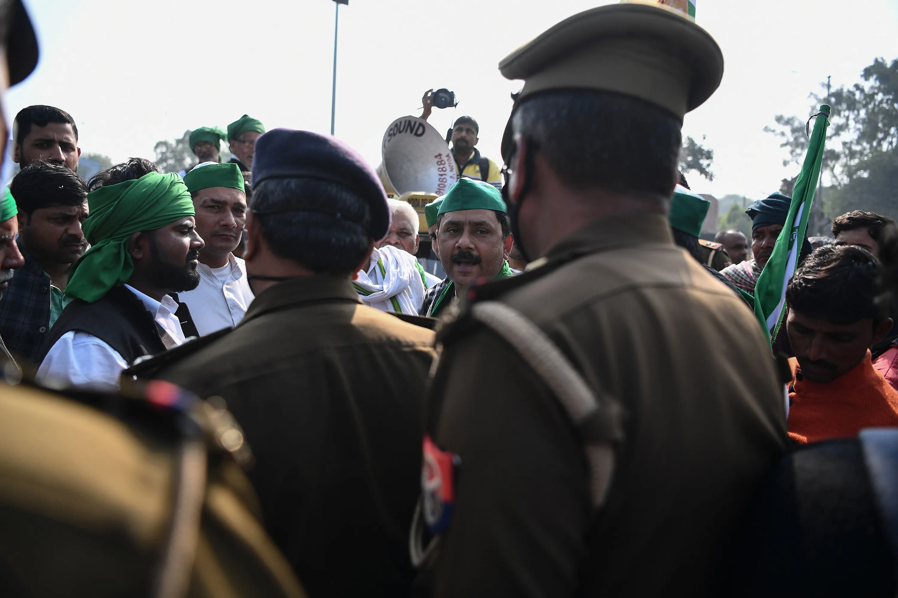 Farmers talk with police officers at a police road block at the Delhi-Uttar Pradesh state border in Noida on Dec. 2.