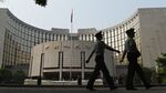 Paramilitary policemen patrol in front of the People's Bank of China in Beijing. China’s central bank will impose required reserve ratios on yuan deposits of offshore participant banks in the mainland in a bid to stabilize the currency.