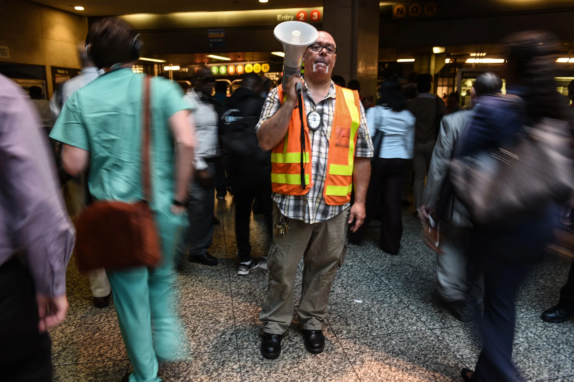 NEW YORK, NY - JULY 10: A Metropolitan Transit Authority employee helps commuters transfer from Long Island railroad service to a New York City subway at the Barclays Center subway station on July 10, 2017 in New York City. Thousands of commuters throughout the New York area are preparing for long delays and the use of alternate forms of transportation as the number of trains into Manhattan is being drastically reduced for the summer track repair work in NY Penn Station.
