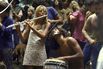 Shirtless male drummer & dress-wearing f