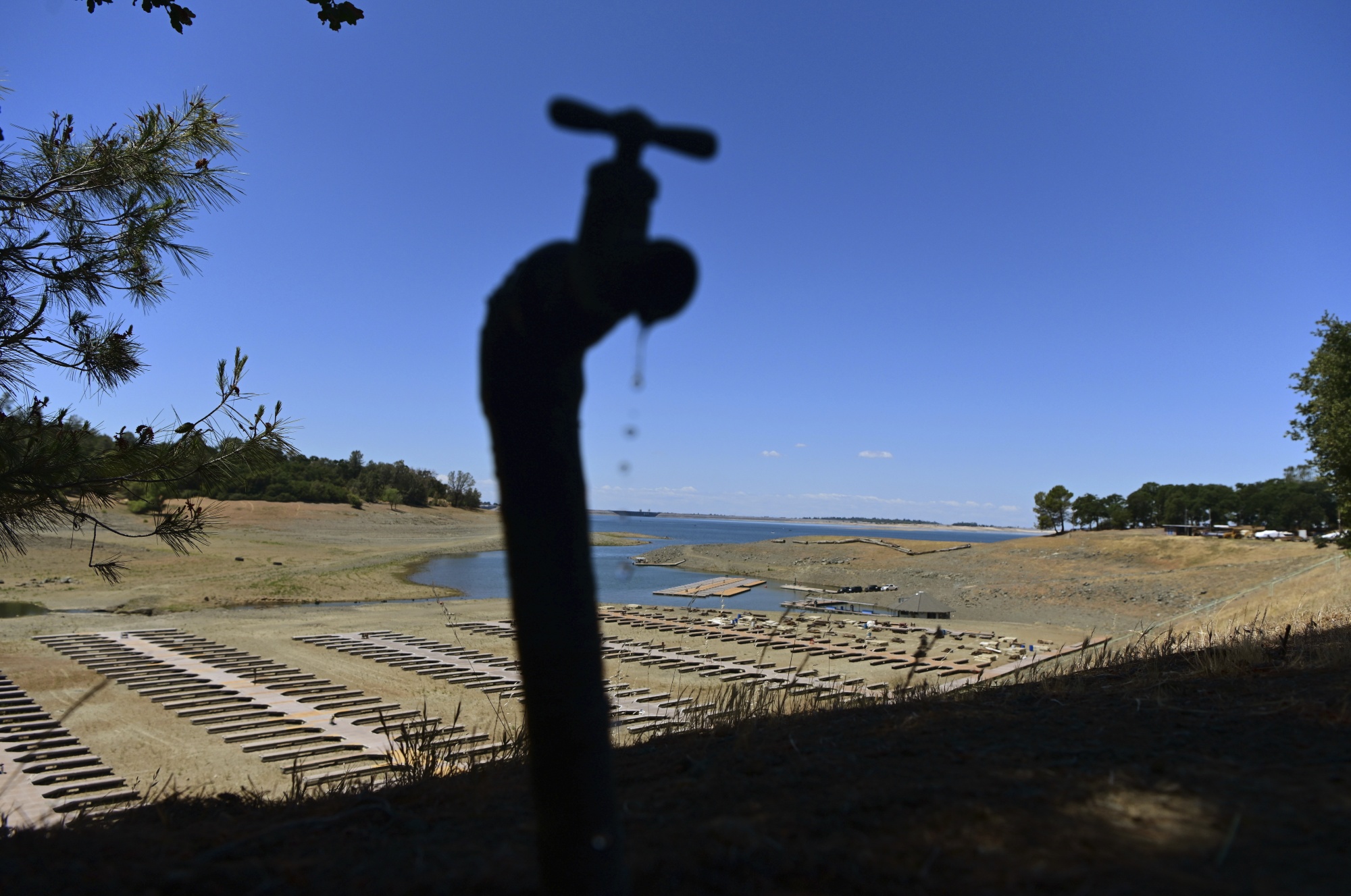 Water drips from a faucet near boat docks sitting on dry land at the Browns Ravine Cove area of drought-stricken Folsom Lake in Folsom, Calif., on May 22, 2022. The American West's megadrought deepened so much last year that it is now the driest it has been in at least 1200 years and a worst-case scenario playing out live, a new study finds. (AP Photo/Josh Edelson, File)