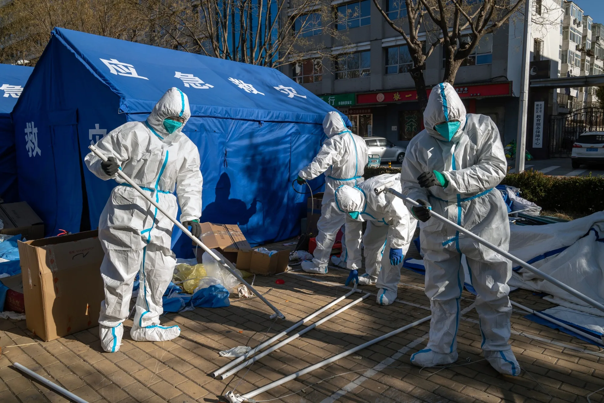 Workers in protective gear dismantle a temporary shelter on Dec. 1 outside a neighborhood that had been placed under lockdown.&nbsp;China’s “Covid zero” stance was suddenly abandoned this month.