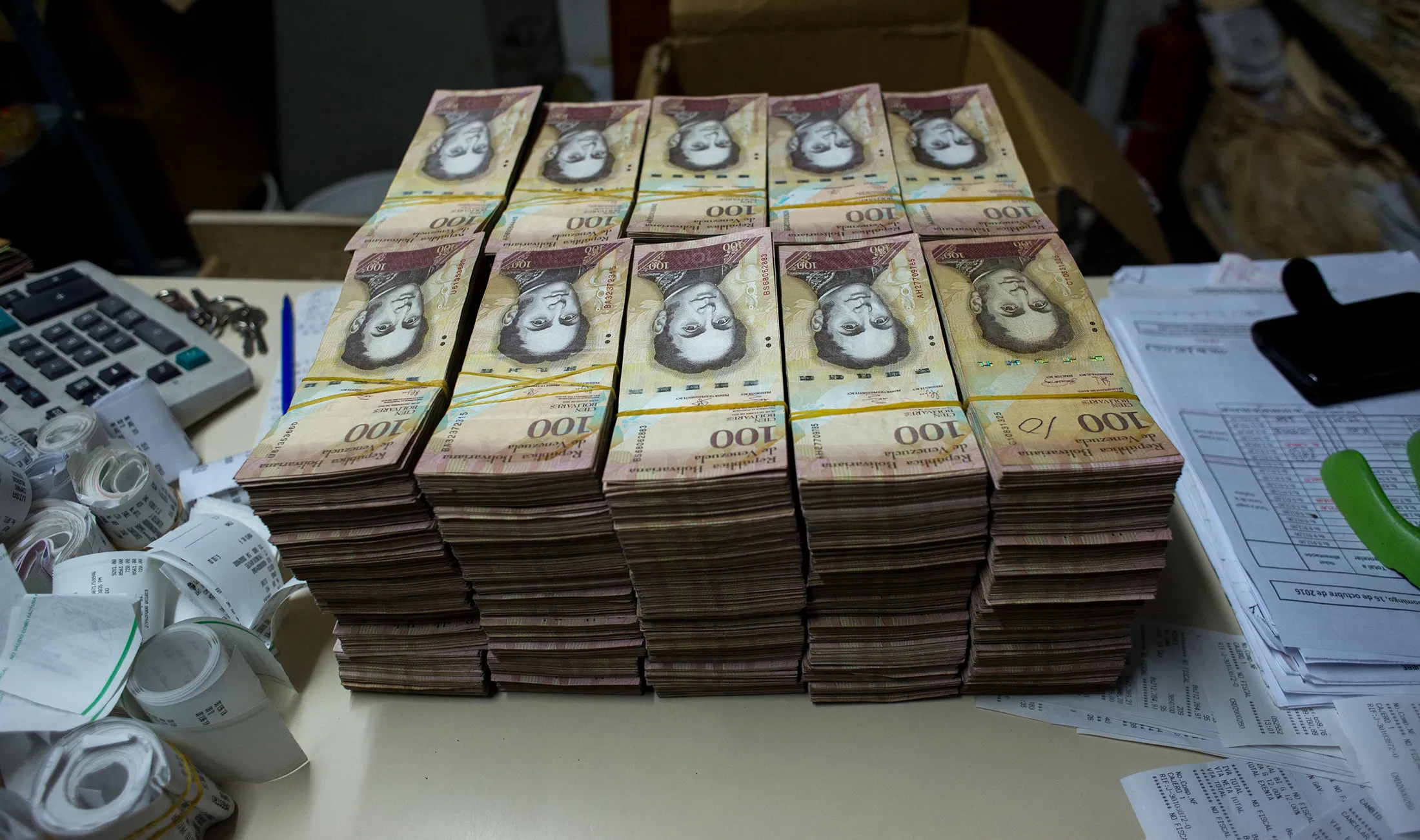 Stacks of banknotes sit on a desk inside the office of a bakery in Caracas Oct. 16, 2016.
