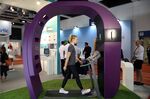 An employee walks on a treadmill inside a giant replica Fitbit watch.
