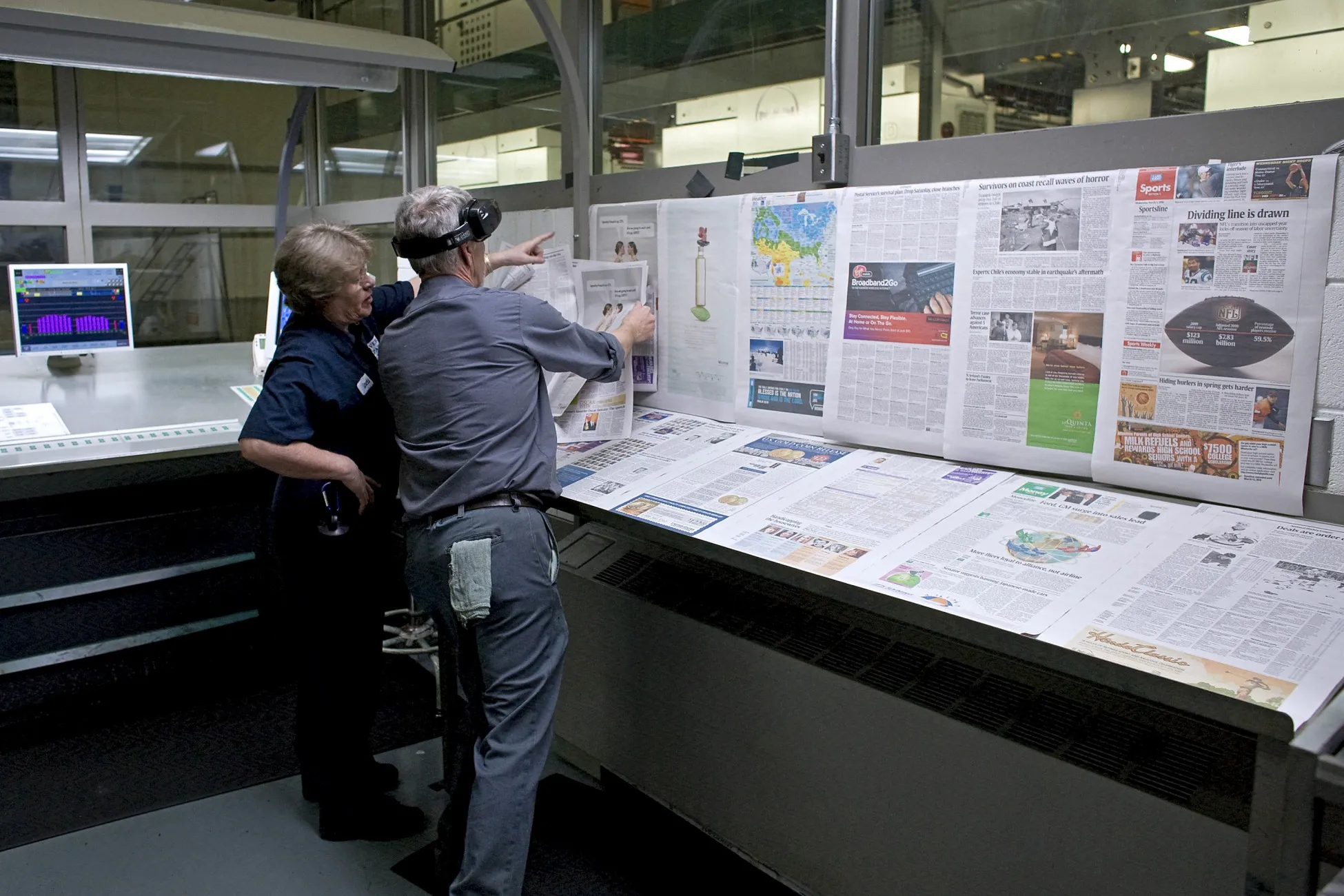 Workers inspect copies of USA Today newspapers.
