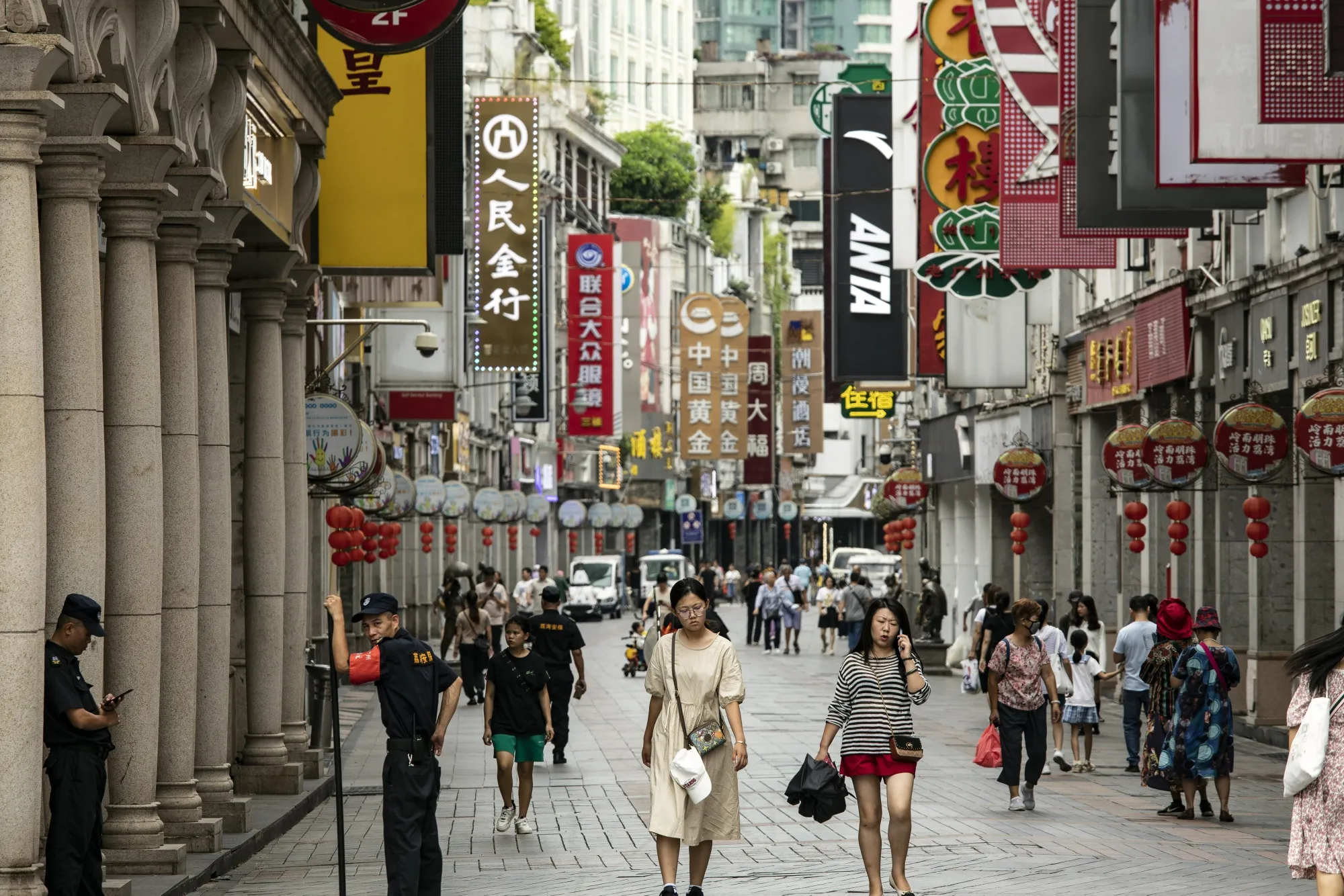 Pedestrians pass stores in Guangzhou, China.